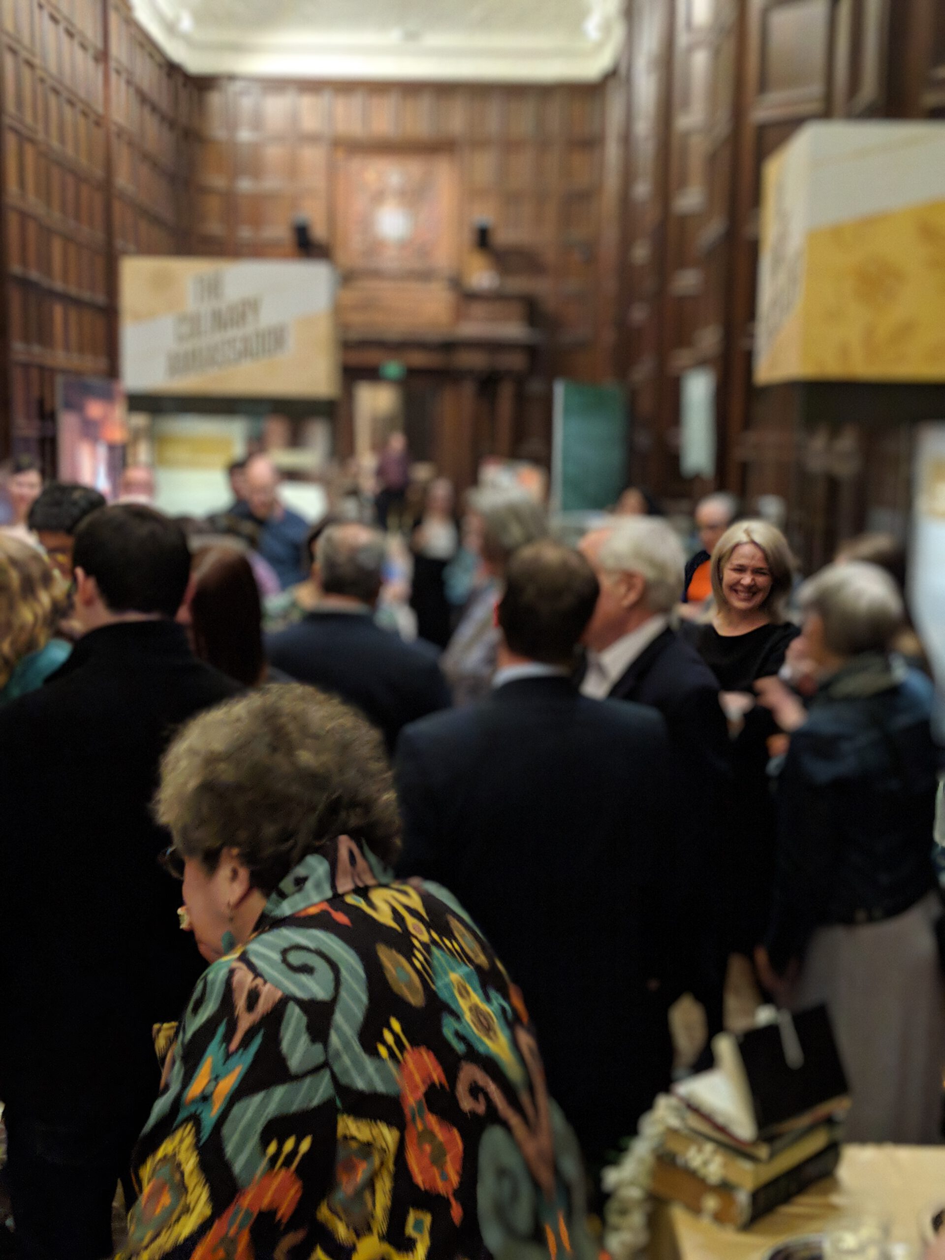 Amanda Herbert talks with visitors in a packed Great Hall during a celebration at the exhibition “First Chefs: Fame and Foodways from Britain to the Americas.”